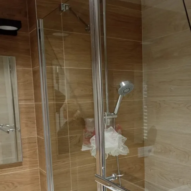 Cabina de duș cu geamul limpede și fără depuneri, după curățare