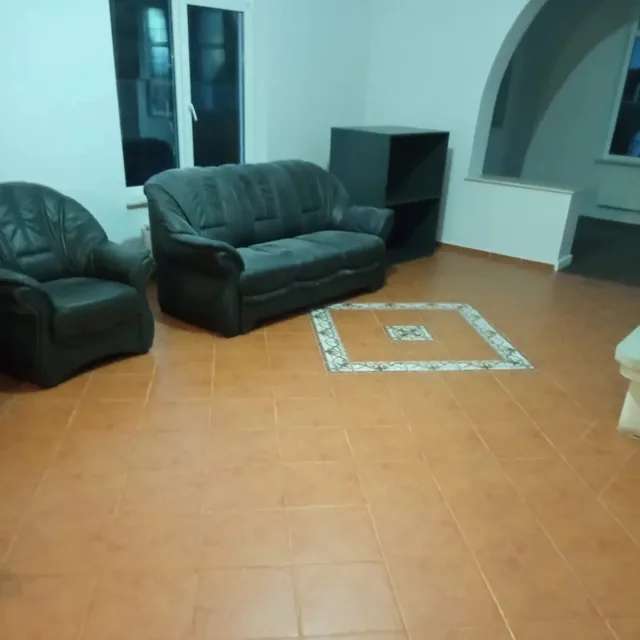 Același living cu gresia curată și mobilierul aranjat, după curățenie