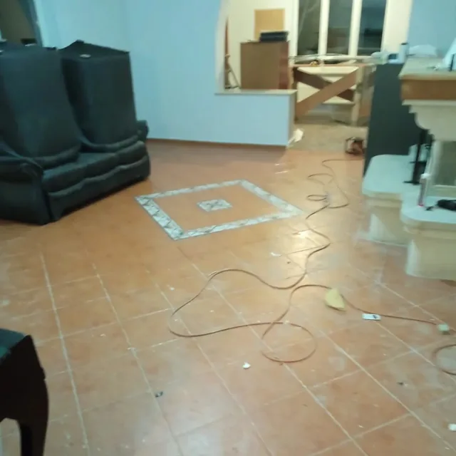 Living cu praf și resturi de construcție pe gresie, înainte de curățenie